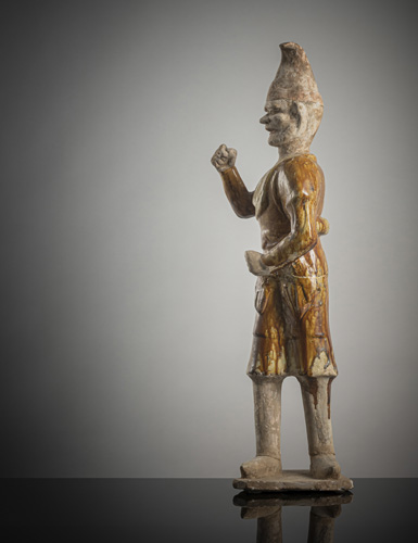 <b>A large amber-glazed earthenware figure of a camel leader</b>