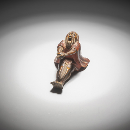 <b>A netsuke of a stretching and yawning Daruma made of wood and lacquer</b>