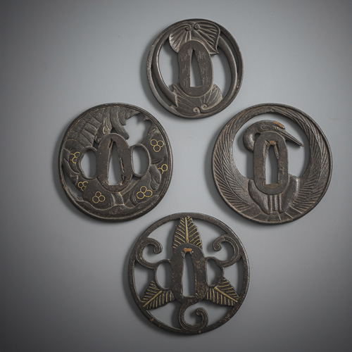 <b>Four tsuba made of iron, partly inlaid in gold or sentoku</b>
