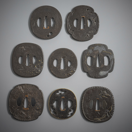 <b>A group of eight iron tsuba, partly decorated with coloured metal</b>