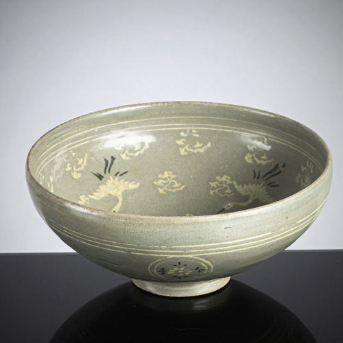 <b>A celadon-glazed bowl with inlaid slip with cranes and clouds</b>