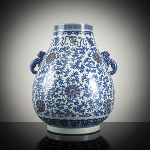 <b>An underglaze blue and copper-red glazed vase in 'hu' form with lotus decoration and foliage next to Buddhist emblems</b>