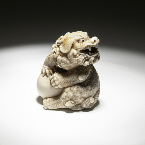 <b>Feines Netsuke eines Shishi aus Elfenbein mit Ball, im Maul eine bewegliche Kugel</b> <b>Feines Netsuke eines Shishi aus Elfenbein mit Ball, im Maul eine bewegliche Kugel</b>