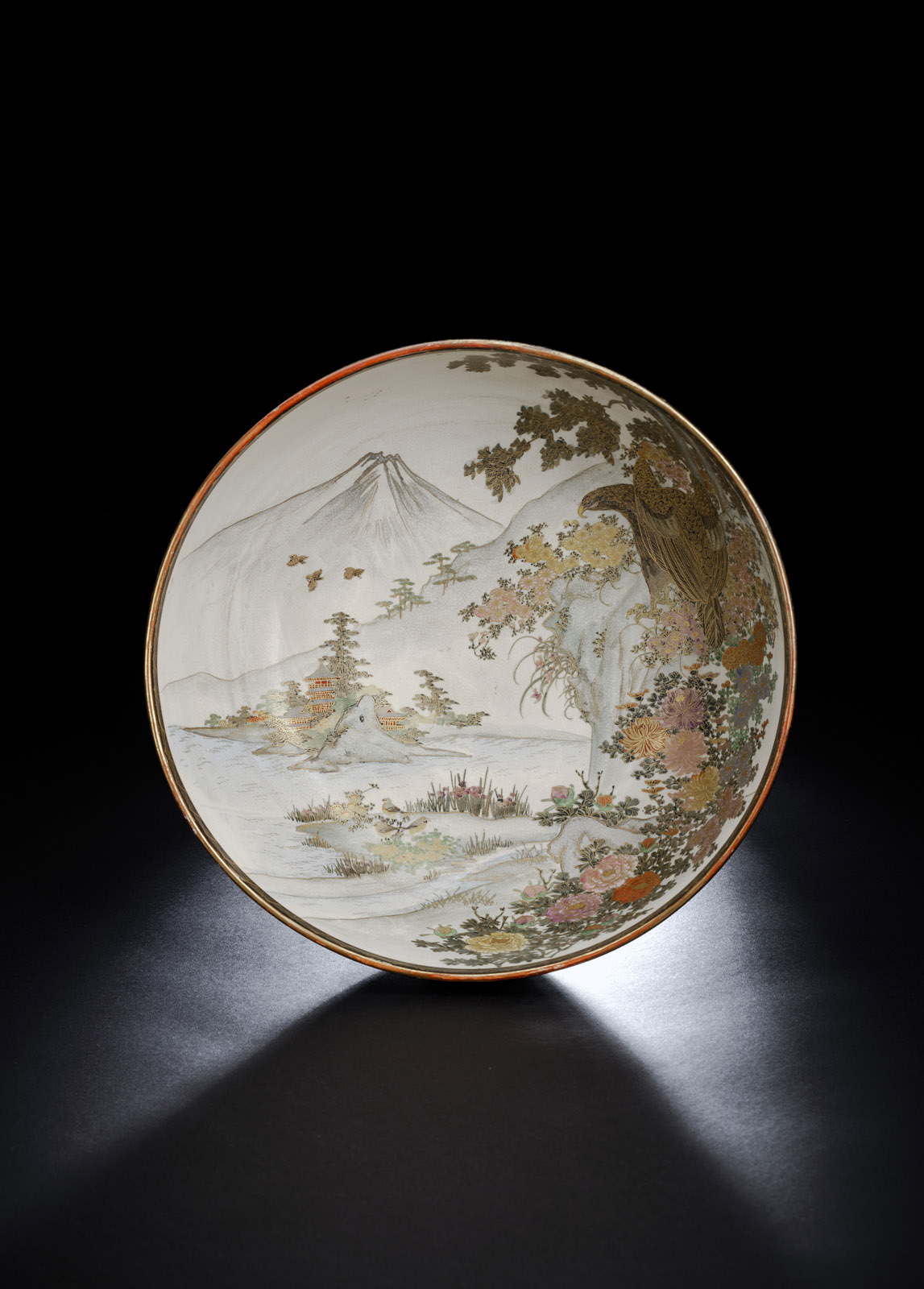 <b>Satsuma-Schale mit Dekor eines Greifvogels im Geäst vor einer Seelandschaft mit Pagoden und dem Berg Fuji</b>