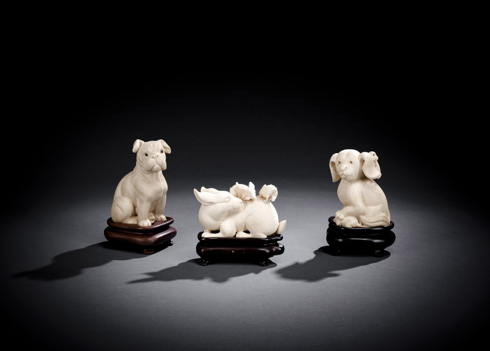 <b>Drei Okimono aus Elfenbein: Zwei Hündchen und Hase mit zwei Jungen</b>
