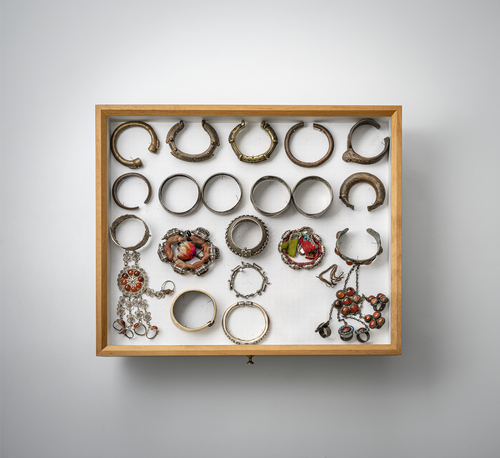 <b>Gruppe von Armbändern, Ketten, Anhängern und Amulett-Dosen, teils in Silber gearbeitet, in zwei Glaskästen montiert</b> <b>Gruppe von Armbändern, Ketten, Anhängern und Amulett-Dosen, teils in Silber gearbeitet, in zwei Glaskästen montiert</b>