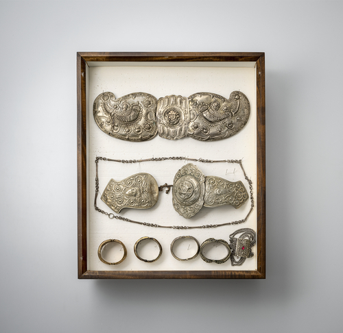 <b>Gruppe von Gürtelschließen, Armreife und Anhänger, teils in Silber gearbeitet, in zwei Glaskästen montiert</b> <b>Gruppe von Gürtelschließen, Armreife und Anhänger, teils in Silber gearbeitet, in zwei Glaskästen montiert</b>