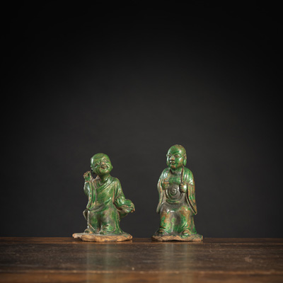 <b>Zwei grün glasierte Figuren von sitzenden Lohan aus Tonware</b>