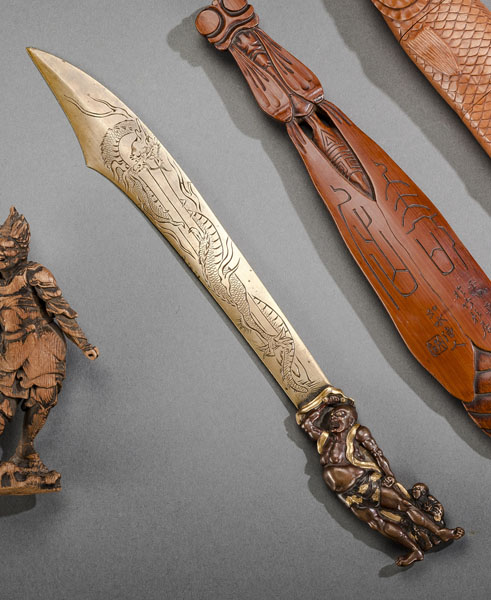 <b>A BRASS AND COPPER PAPER KNIFE, THE HANDLE DECORATED WITH A FIGURE OF NIÔ AND A MAN</b>