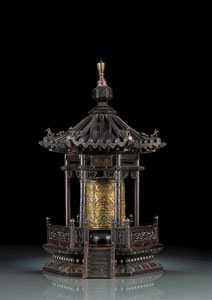 <b>A GILT-BRONZE PRAYER WHEEL MOUNTED IN A CARVED WOOD PAGODA-SHAPED TEMPLE</b>