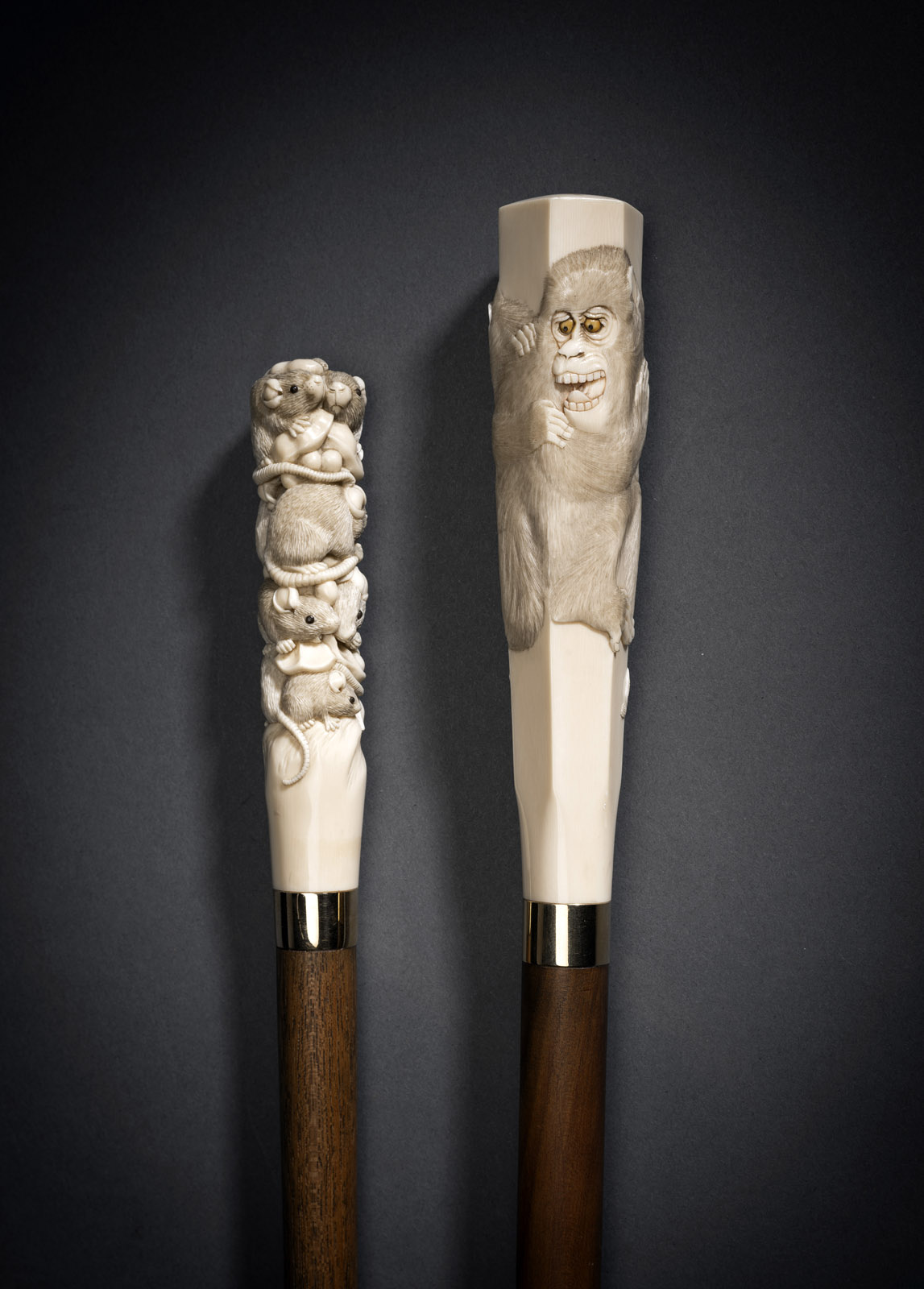 <b>TWO WOODEN STAFFS WITH FINELY CARVED IVORY HANDLES DECORATED WITH RATS AND MONKEYS</b>