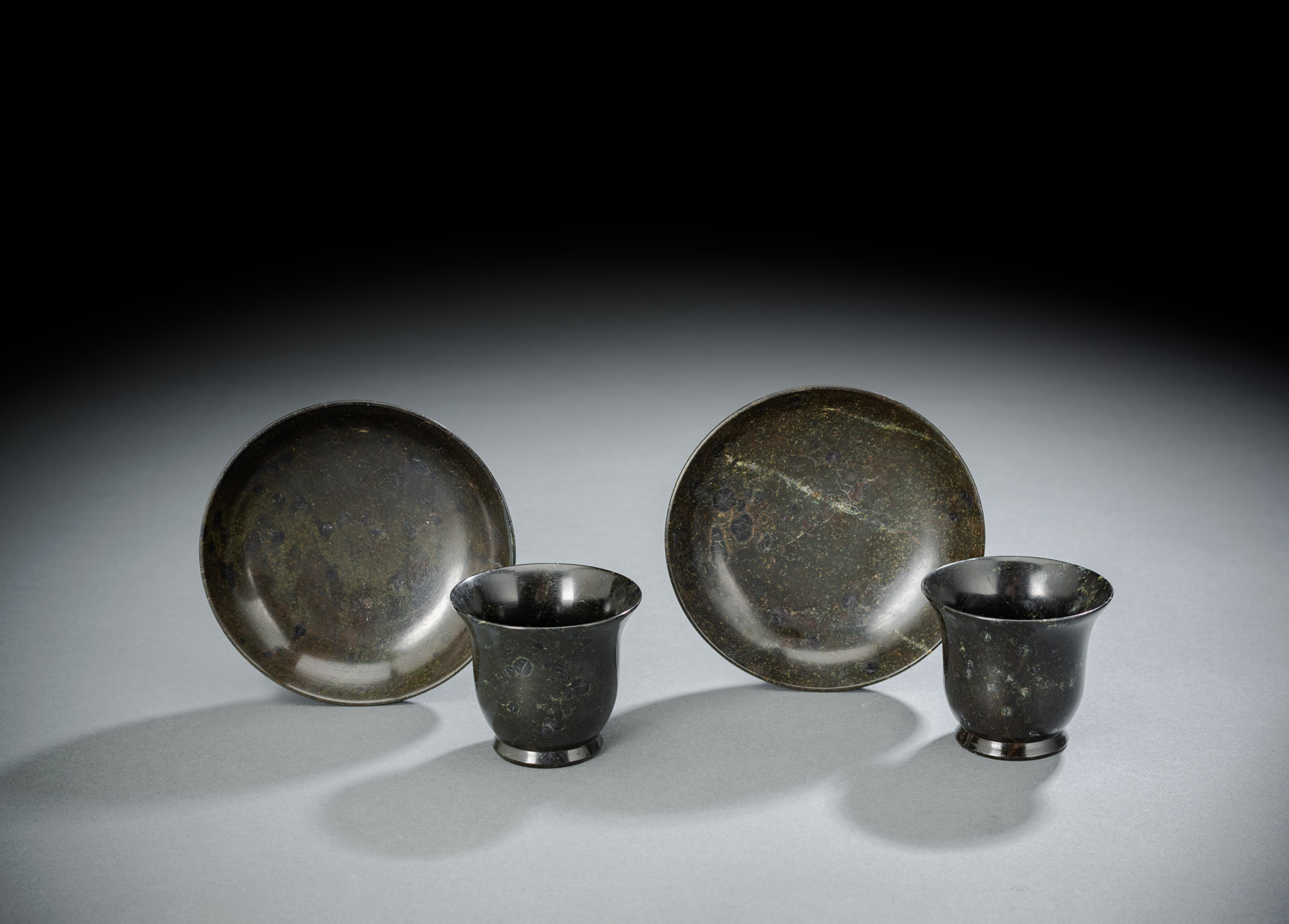 <b>A PAIR OF GREEN-BLACK SERPENTINE CUPS AND SAUCERS</b>