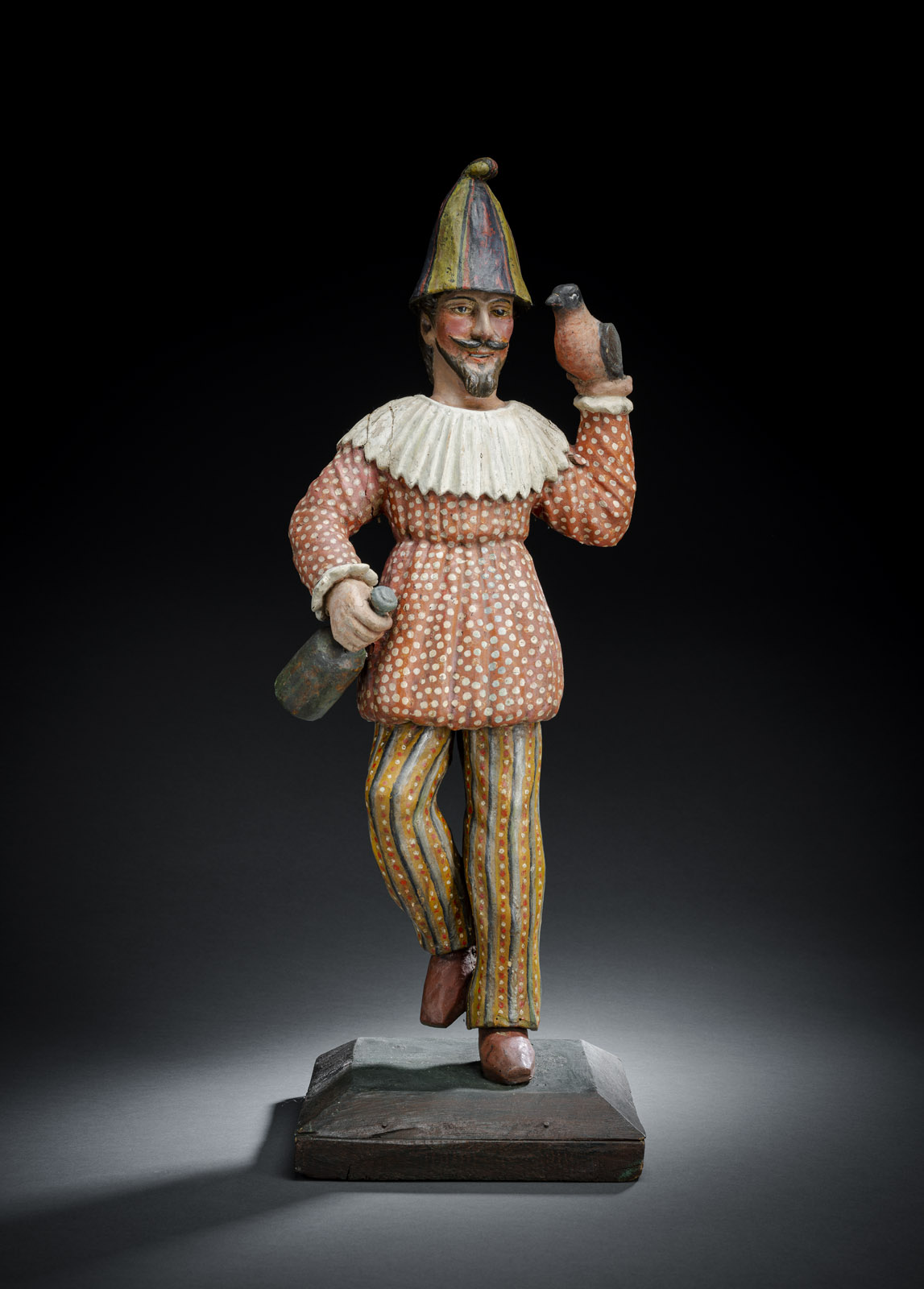 <b>A RARE WOOD FIGURE OF HARLEQUIN WITH A PARROT AND A BOTTLE</b>